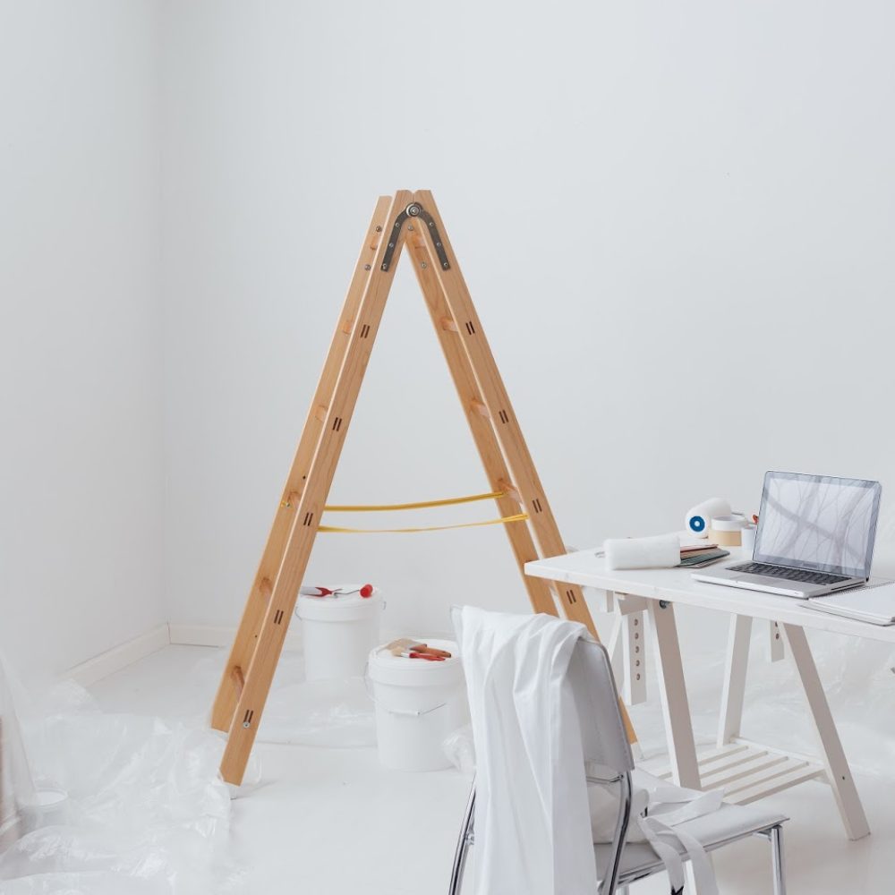 Home makeover, renovation and decoration: home interior with a ladder, boxes, paint buckets and tools